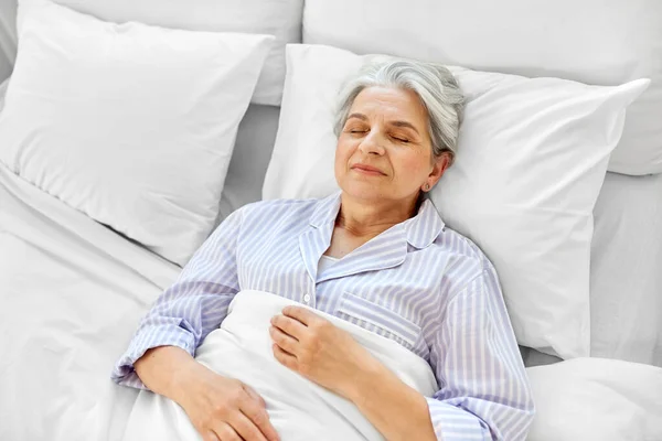 Wanita senior yang bahagia tidur di kamar tidur di rumah — Stok Foto