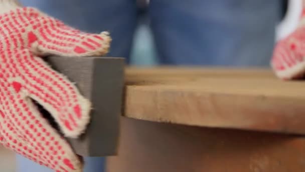 Женщина шлифует старый круглый деревянный стол с губкой — стоковое видео