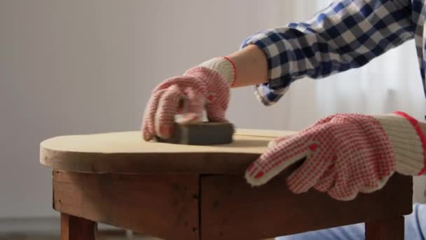 Mulher lixar mesa de madeira redonda velha com esponja — Vídeo de Stock