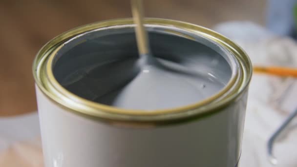 Деревянная палка помешивая серый цвет краски в банке — стоковое видео