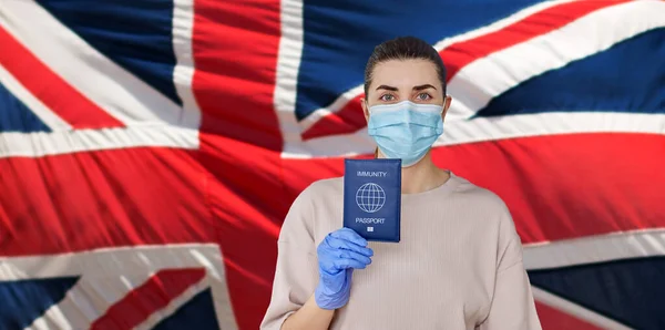 Maskeli ve eldivenli kadın dokunulmazlık pasaportu taşıyor. — Stok fotoğraf