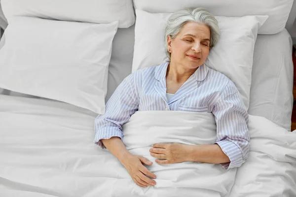 Felice donna anziana dormire a letto a casa camera da letto — Foto Stock