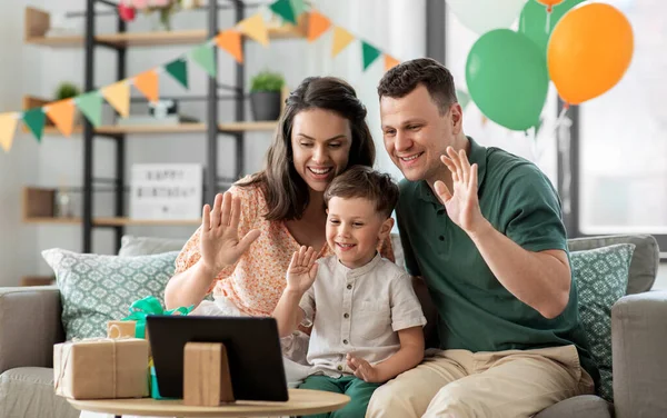 Familia con tableta PC tiene videollamada en el cumpleaños Imagen De Stock