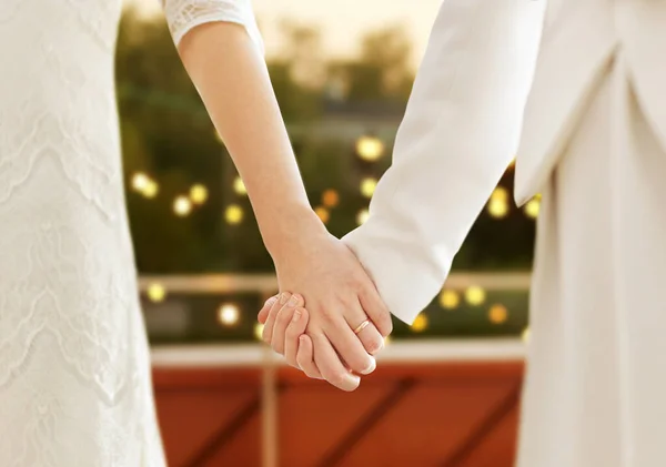 close up of married lesbian couple holding hands