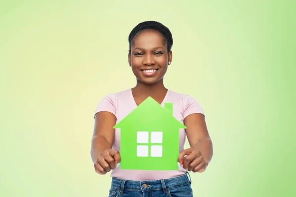 Sorridente afro-americano mulher segurando casa verde — Fotografia de Stock