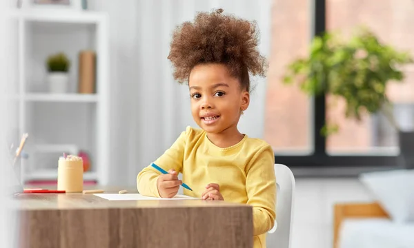 Маленькая девочка с войлочной ручкой рисунок дома — стоковое фото