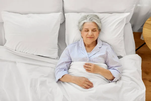 Felice donna anziana dormire a letto a casa camera da letto — Foto Stock