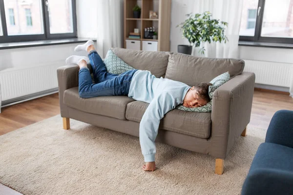 Młody człowiek śpi na kanapie w domu — Zdjęcie stockowe