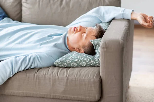 Молодой человек спит дома на диване — стоковое фото