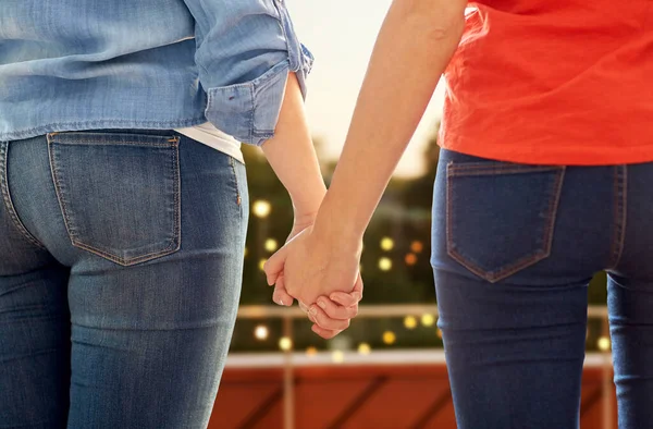 Крупным планом лесбийская пара, держащаяся за руки на вечеринке — стоковое фото