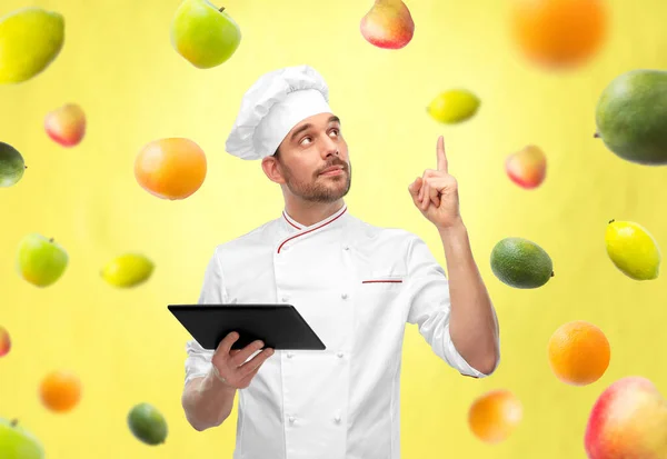 Chef masculino con tableta apuntando con el dedo hacia arriba —  Fotos de Stock