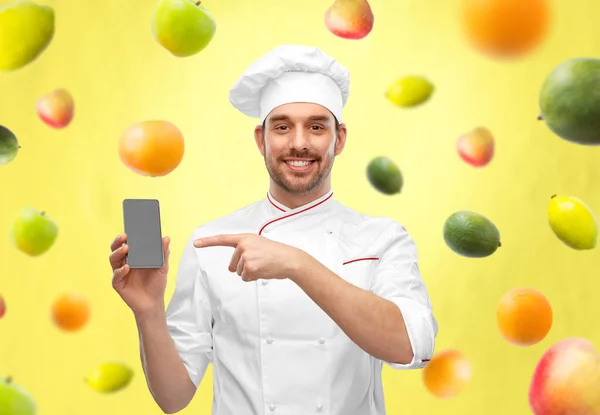 Feliz chef masculino sonriente mostrando teléfono inteligente —  Fotos de Stock
