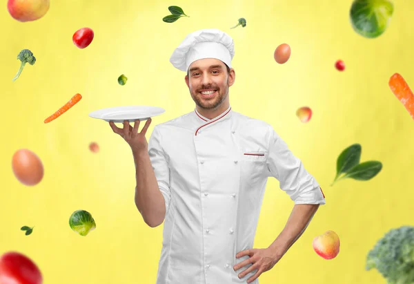Glad leende manlig kock håller tom tallrik — Stockfoto