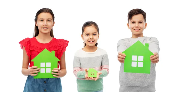 Niños sonrientes sosteniendo iconos de casa verde — Foto de Stock