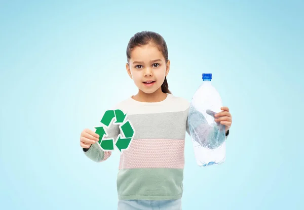 Menina com sinal de reciclagem verde e garrafa de plástico — Fotografia de Stock