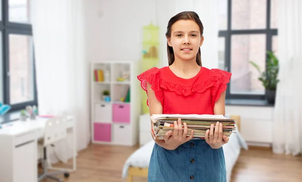 Menina sorridente com revistas triagem de resíduos de papel — Fotografia de Stock