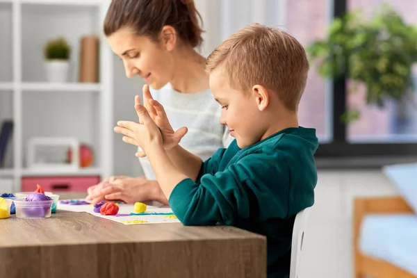 Mãe e filho brincando com argila modelagem em casa — Fotografia de Stock