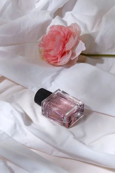 Bottle of perfume and flower on white sheet — Stock Photo, Image