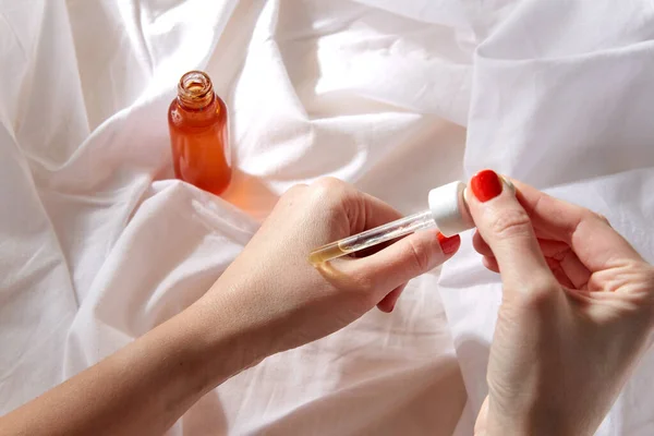 Female hands with dropper applying serum to skin — Stock Photo, Image