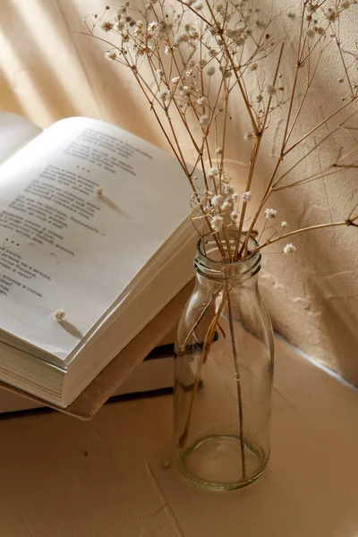 Книги и декоративные сушеные цветы в стеклянной бутылке — стоковое фото