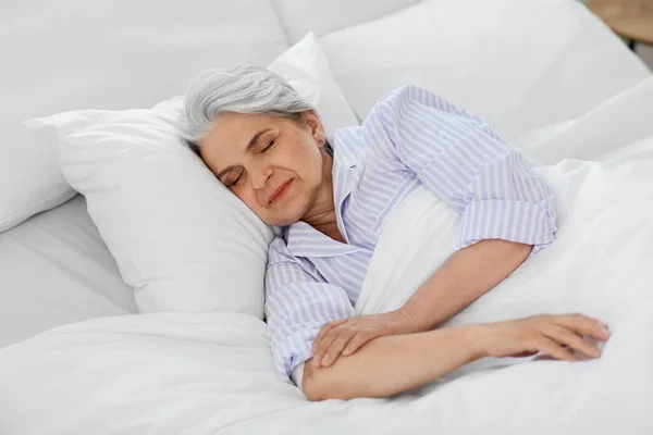 Пожилая женщина спит в постели в спальне — стоковое фото