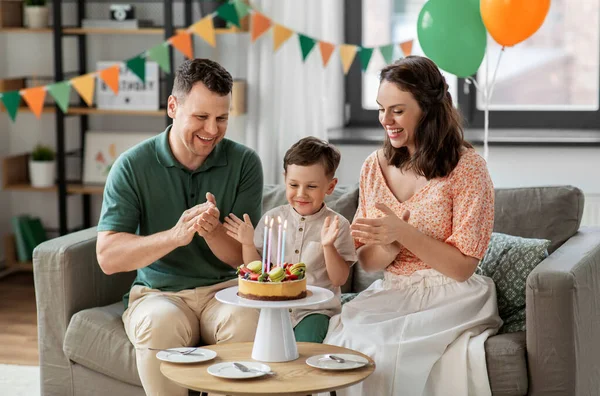 Šťastná rodina s narozeninovým dortem doma — Stock fotografie