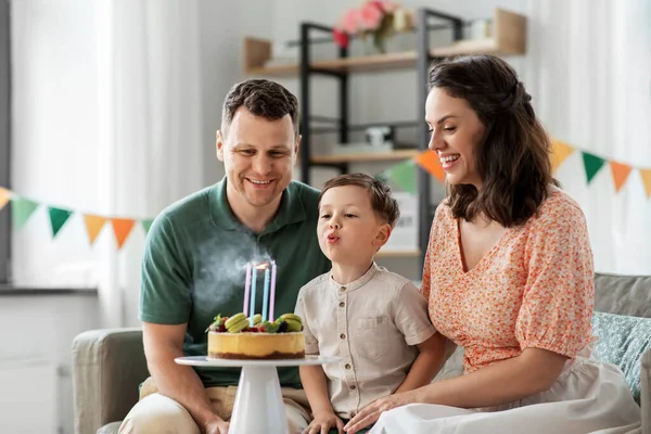 Família feliz com bolo de aniversário em casa — Fotografia de Stock