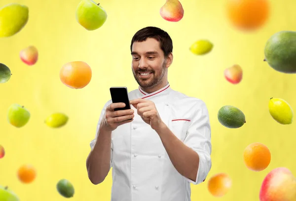 Felice chef maschio sorridente con smartphone Foto Stock