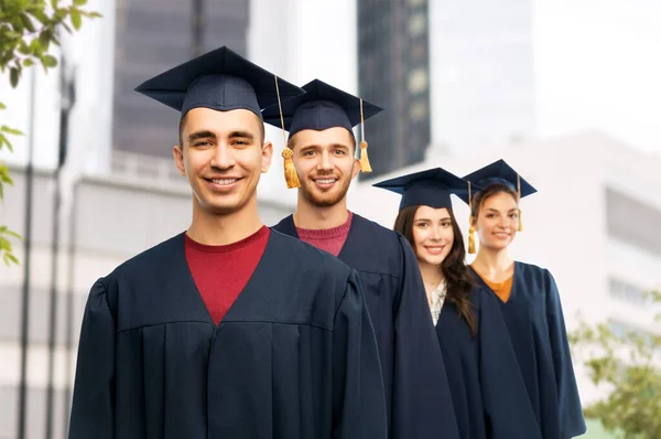 Graduados em placas de argamassa e vestidos de solteiro — Fotografia de Stock