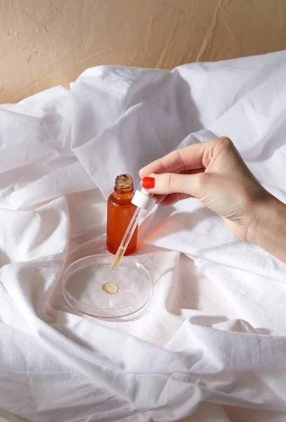 Vrouwelijke hand met druppelaar die serum op glas aanbrengt — Stockfoto