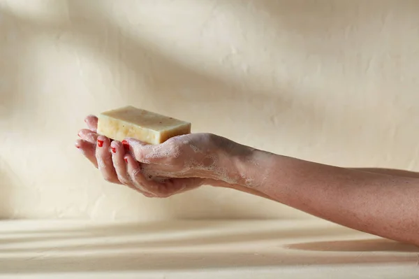 Mãos espumosas segurando barra de sabão artesanal — Fotografia de Stock