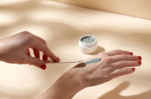 Ruce nanášení modré kosmetické hliněné masky na kůži — Stock fotografie
