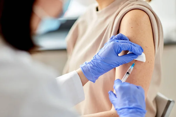 Vrouwelijke arts met injectiespuit vaccinerende patiënt — Stockfoto