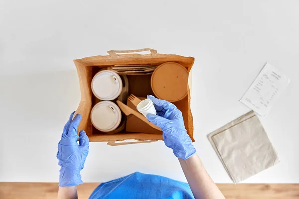 Entrega mujer en guantes embalaje alimentos y bebidas —  Fotos de Stock