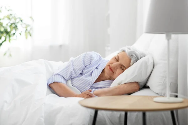Mujer mayor durmiendo en la cama en casa dormitorio —  Fotos de Stock