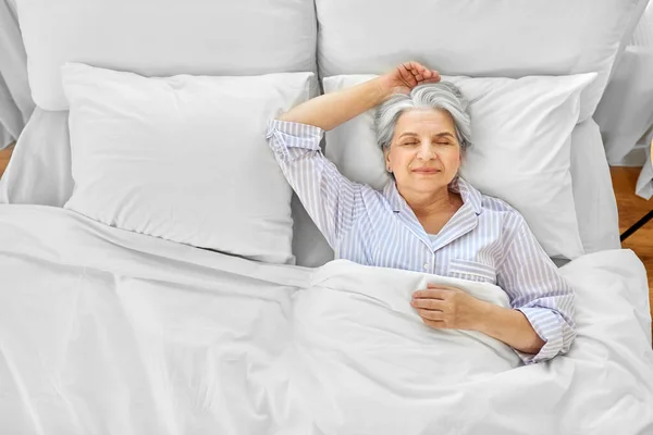 Пожилая женщина спит в постели в спальне — стоковое фото