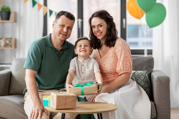 Padres dando regalo de cumpleaños a su hijo pequeño Fotos De Stock