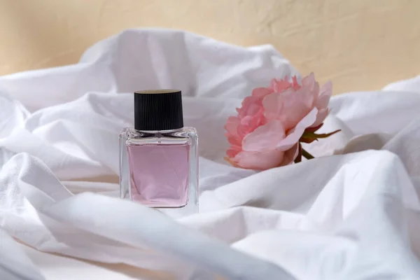 Bottle of perfume and flower on white sheet — Stock Photo, Image