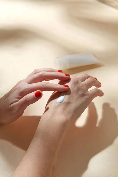 Γυναικεία χέρια που εφαρμόζουν ενυδατική κρέμα στο δέρμα — Φωτογραφία Αρχείου