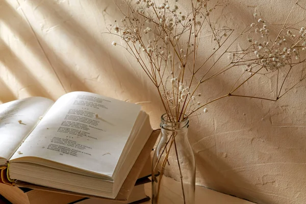 Books and decorative dried flowers in glass bottle — Stock Photo, Image