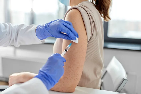 Vrouwelijke arts met injectiespuit vaccinerende patiënt — Stockfoto