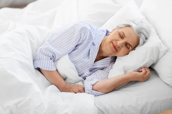 Mulher sênior dormindo na cama em casa quarto — Fotografia de Stock