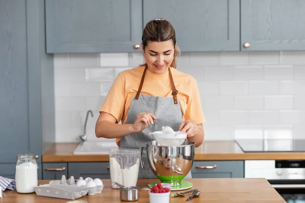 Jovem feliz cozinhar comida na cozinha em casa — Fotografia de Stock