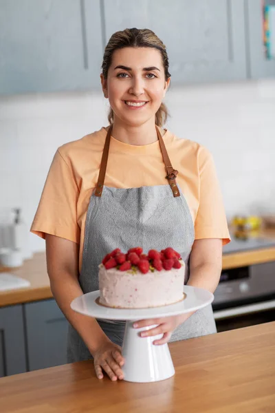 Femme heureuse avec gâteau framboise sur la cuisine à la maison — Photo