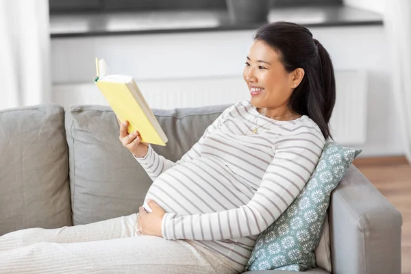 Boldog terhes nő olvasás könyv otthon — Stock Fotó