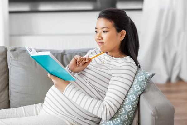 Femme enceinte écrivant au journal intime à la maison — Photo