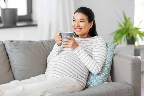Šťastná těhotná žena pije čaj doma — Stock fotografie