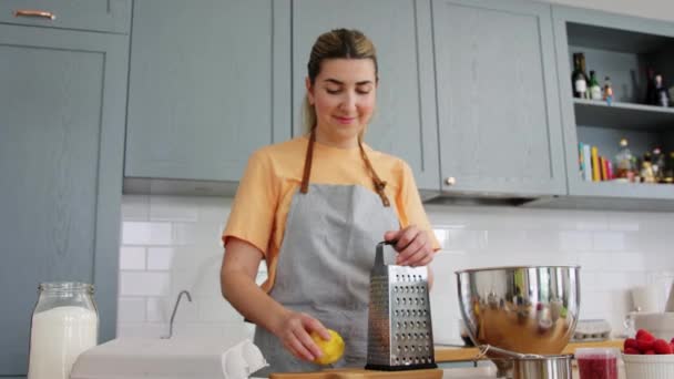 Mujer rallado cáscara de limón en rallador en casa cocina — Vídeo de stock