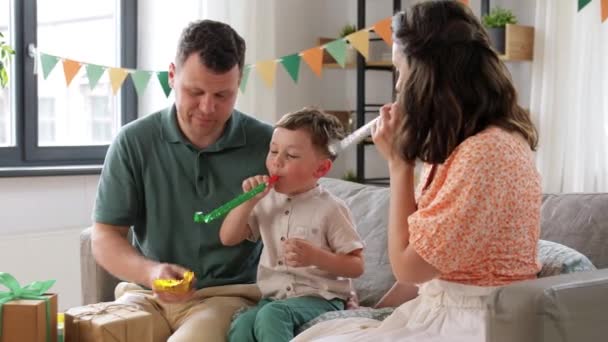 Glückliche Familie mit Geschenken und Partybläser zu Hause — Stockvideo