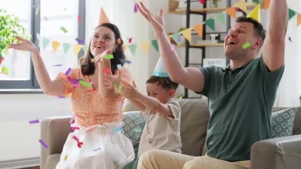 Parti şapkalı mutlu aile doğum gününü kutluyor. — Stok video